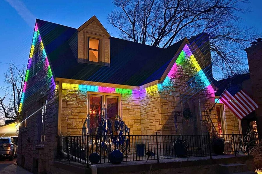 A brick home with an Easter Trimlight pattern with an American flag,