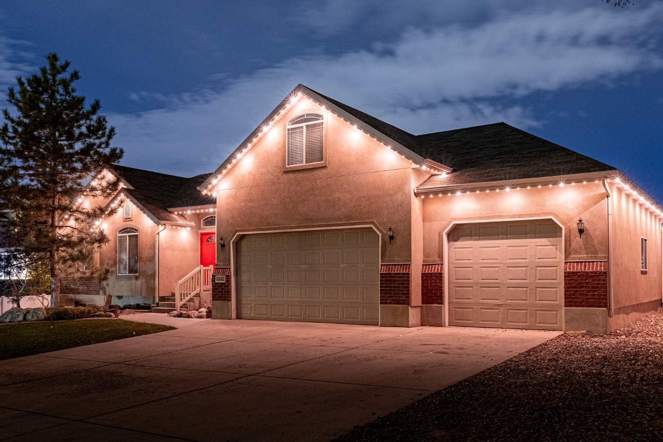 A picture of a home with a warm white pattern and a large driveway in the front