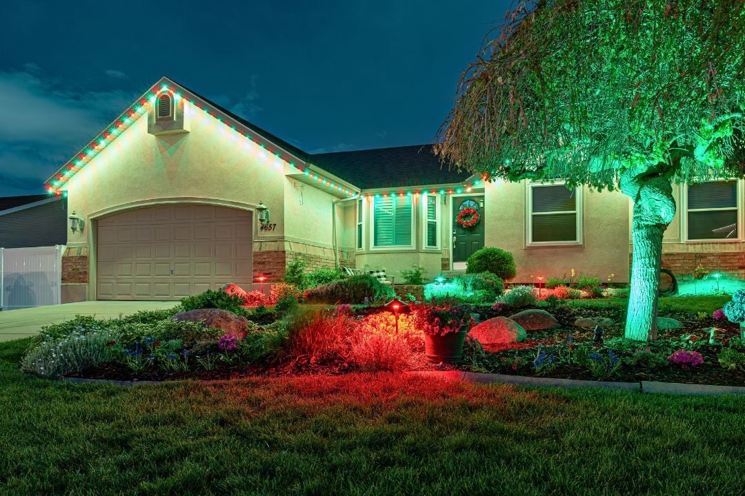 A home that has christmas Trimlight lighting and has christmas style landscape lighting in front of the home.