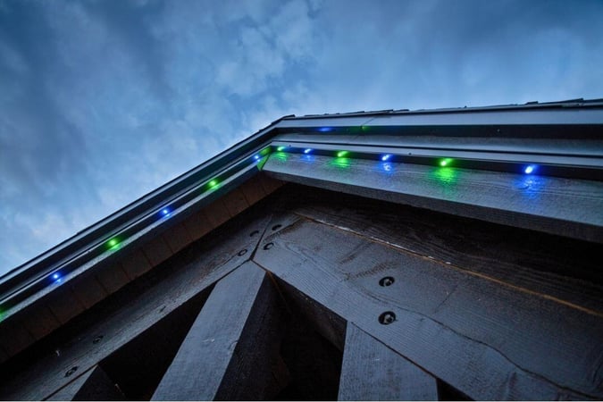 A home that has green and blue lights but spread apart on a black wooden home closeup
