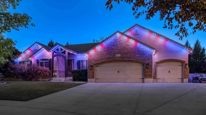a home with a big driveway and 5 peaks on the home. It features a American Flag Trimlight pattern.