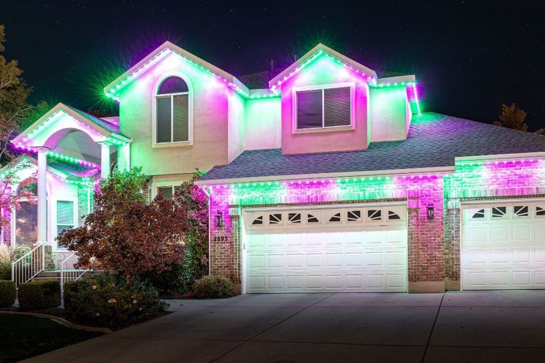 A picture of a home that has a tree in front and a driveway that features on the home green pink and white colors.