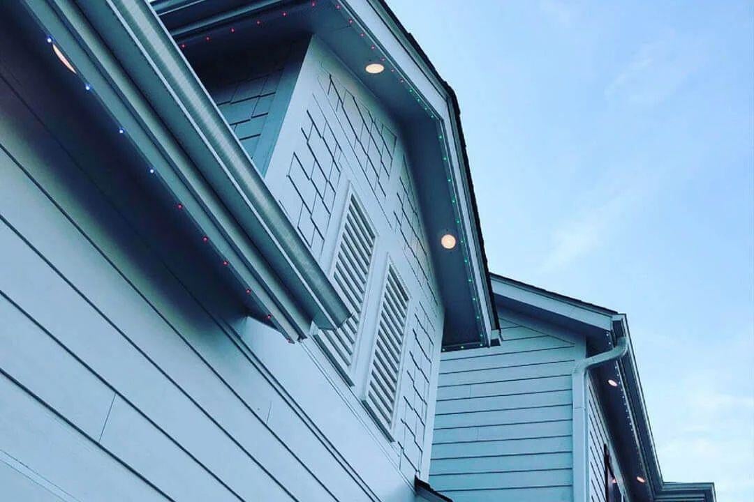 An upshot picture of a home that has downlights and Trimlight that is on during the day.