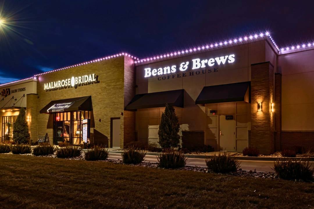 Beans and Bews Storefront with Malmrose Bridal right next to it, with bright LED accent lighting across the whole building.
