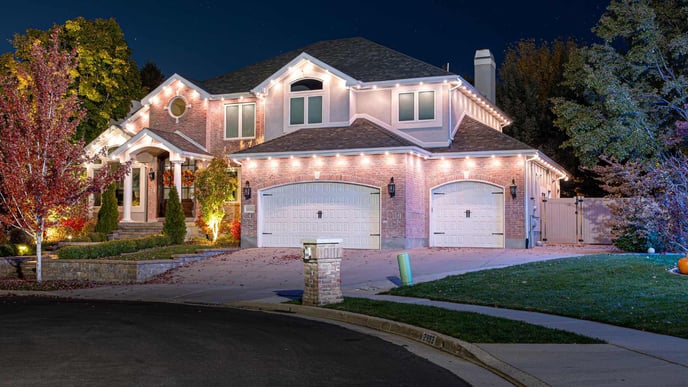 Brick stucco home with accent lighting around edge of roofline.