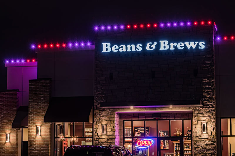 Exterior of coffee shop with Trimlights glowing