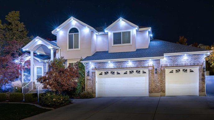 Modern home with three peaks out front and edge lighting for aesthetic and security purposes.