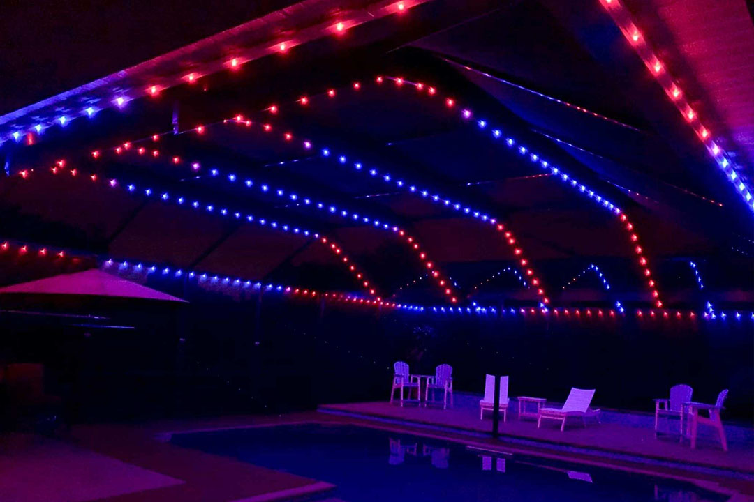 a picture of a pool cage with red and blue colored Trimlight.