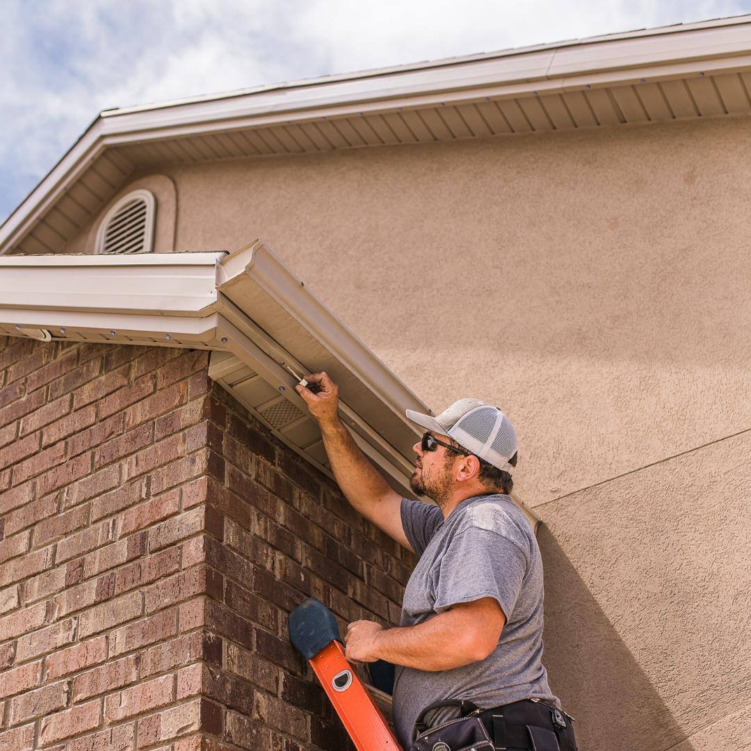 Trimlight installer installing a color-matched channel to sandstone home.