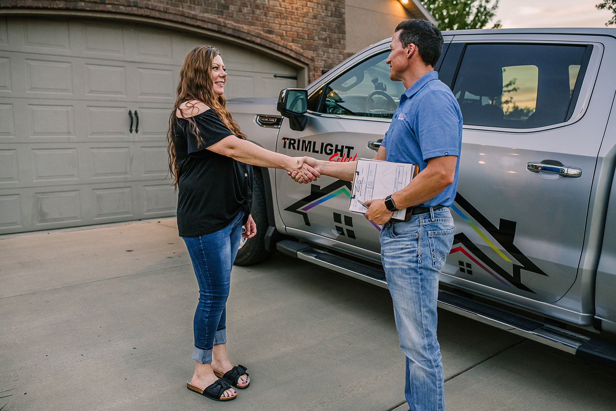 A happy customer shaking hands with a licensed Trimlight dealer