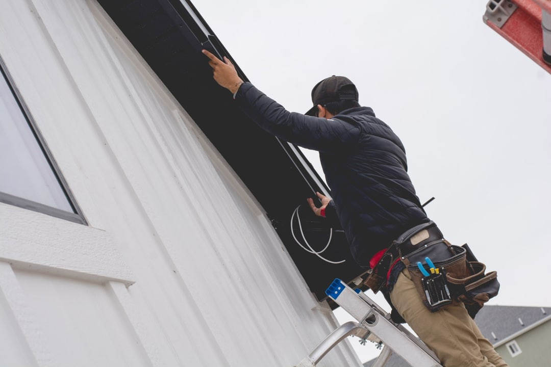 A licensed Trimlight technician installing trim lighting on a new house.