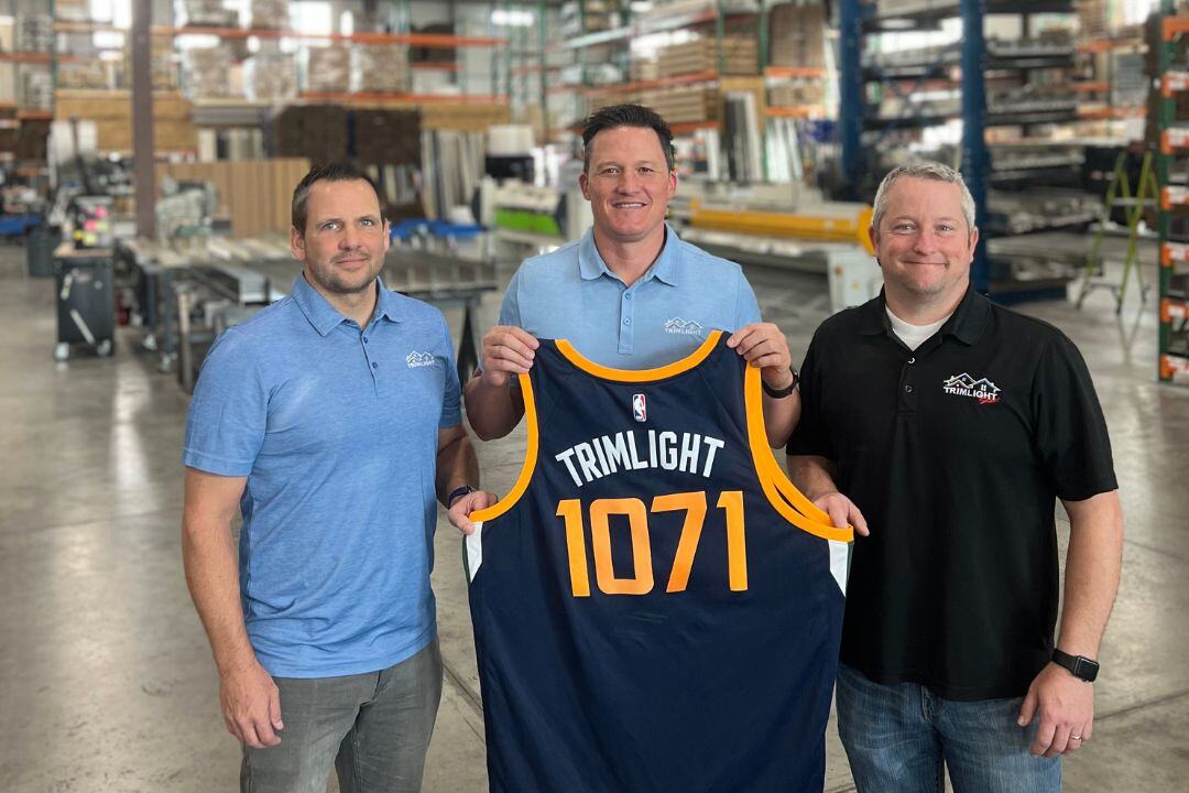 Trimlight owners holding up a Utah Jazz Trimlight jersey inside